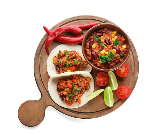 Chili con carne en un tazón con tortillas y verduras aisladas en blanco