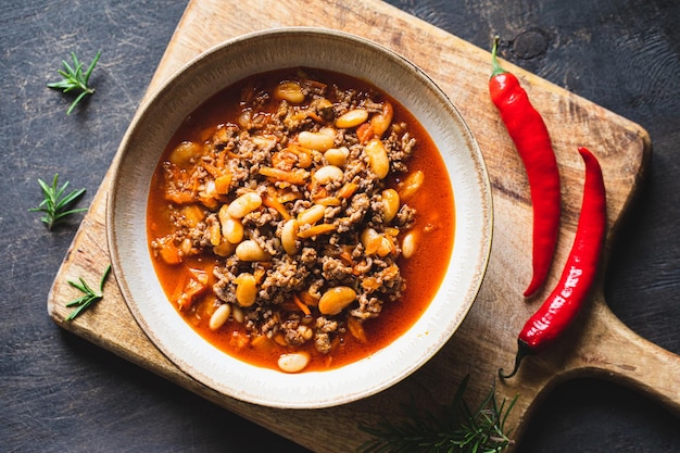 Chili Con Carne em tigela sobre fundo escuro Cozinha mexicana chili com carne ensopado de carne e legumes em molho de tomate Vista superior