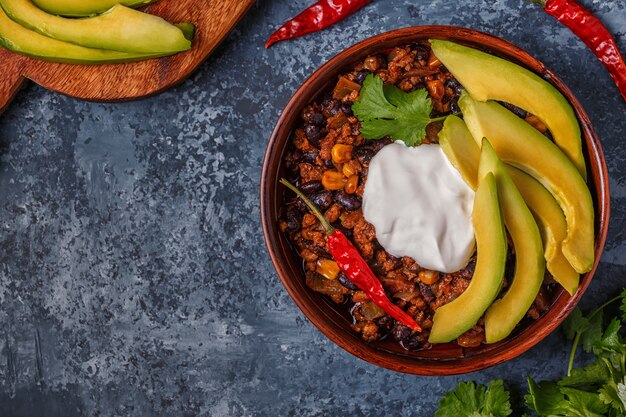 Chili con Carne in einer Schüssel mit Avocado und Sauerrahm