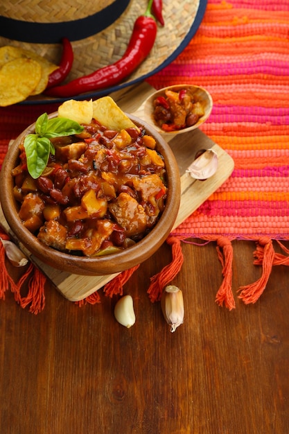 Chili Corn Carne traditionelles mexikanisches Essen in Holzschale auf Serviette auf Holzhintergrund
