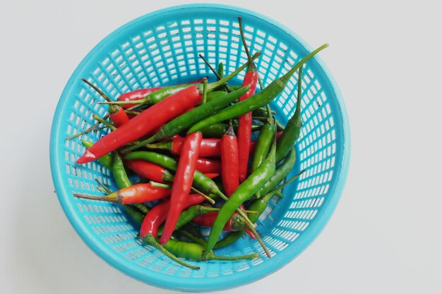 Foto chili está em uma cesta de plástico azul isolado em um fundo branco