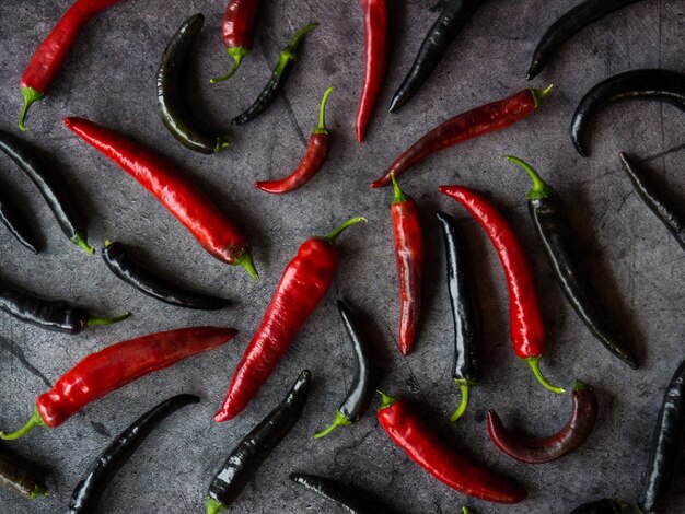 Chilischoten aus rotem und schwarzem Pfeffer auf dunklem Betongrund