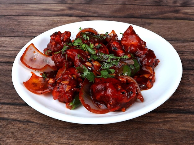 Chilli Chicken es un entrante chino indio servido sobre un enfoque selectivo de fondo rústico de madera