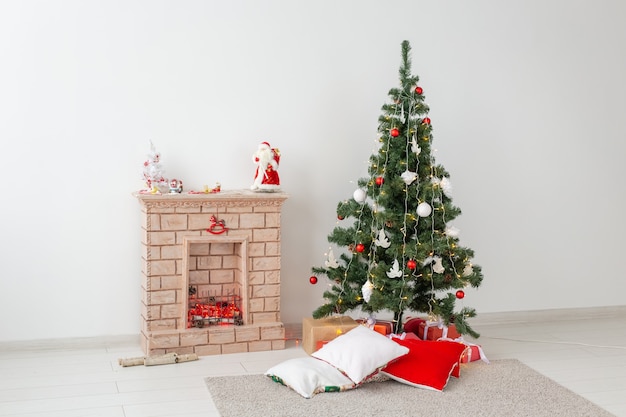 Chimenea y árbol de Navidad con regalos en salón.