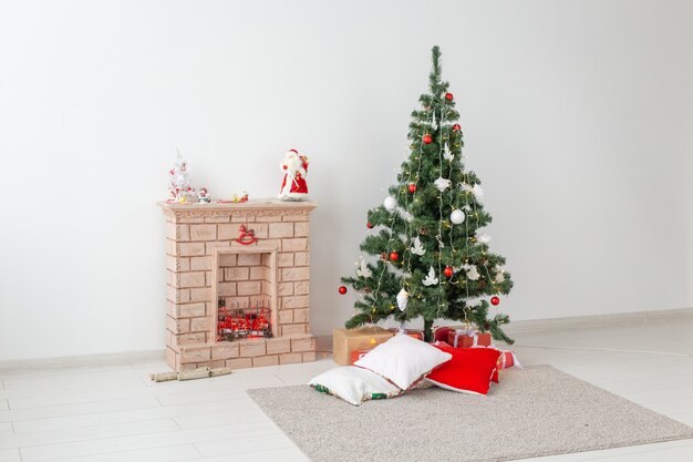 Chimenea y árbol de Navidad con regalos en salón.