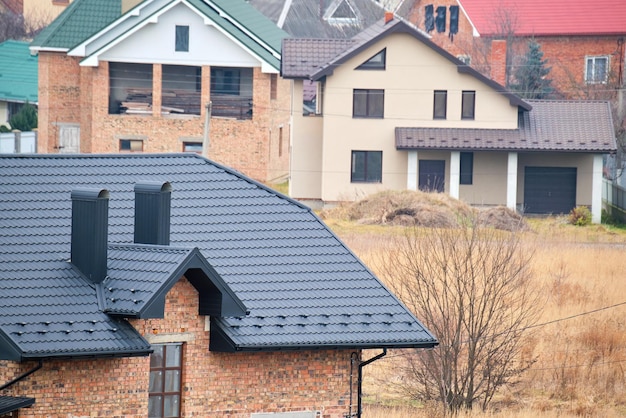 Chimenea en la azotea de la casa cubierta con tejas metálicas en construcción Revestimiento de azulejos del edificio Desarrollo inmobiliario