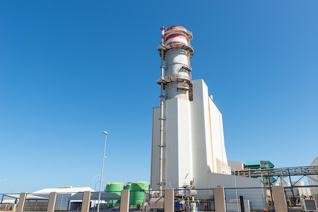 Chimenea de la central eléctrica en un día despejado contra un cielo despejado