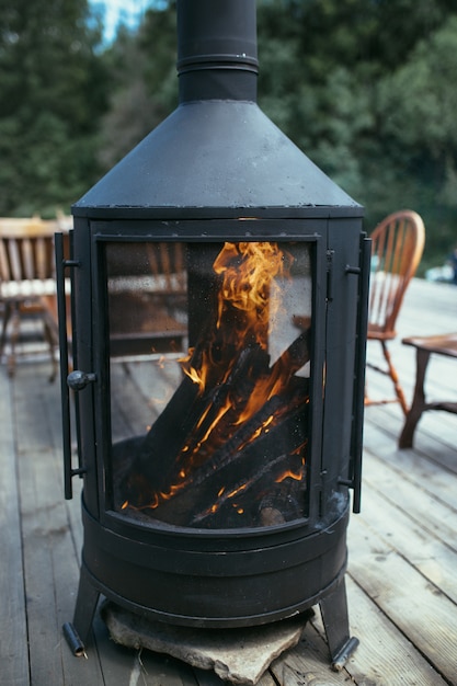 Chimenea de estufa con leña en la calle.