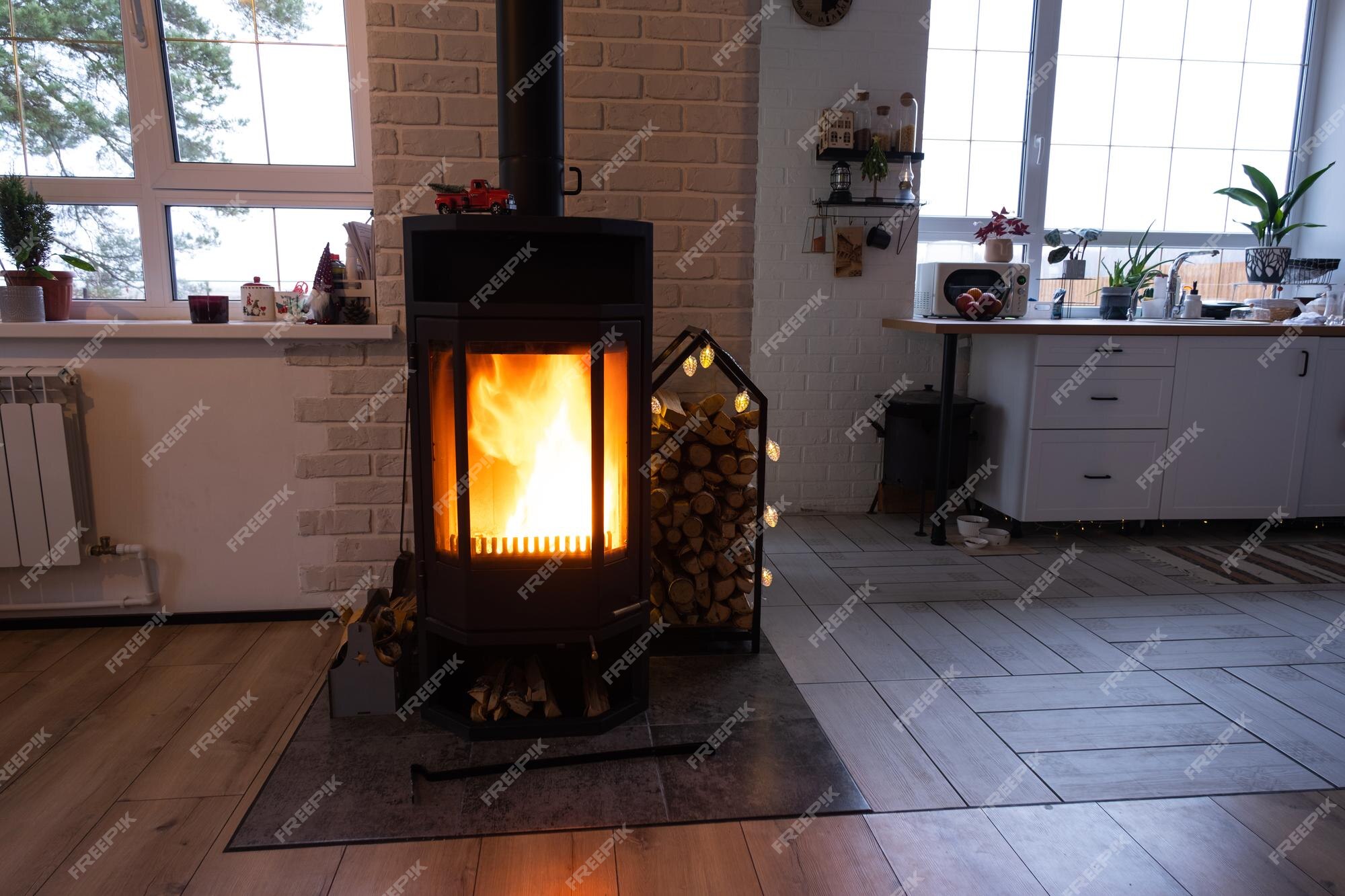 Hito reunirse Tierras altas Chimenea de estufa de metal negro con madera en una pila de leña el  interior de una casa de pueblo privada calefacción y calefacción de la casa  con leña el calor del fuego del hogar | Foto Premium