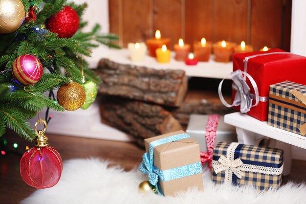 Chimenea con hermosas decoraciones navideñas y regalos en la habitación.