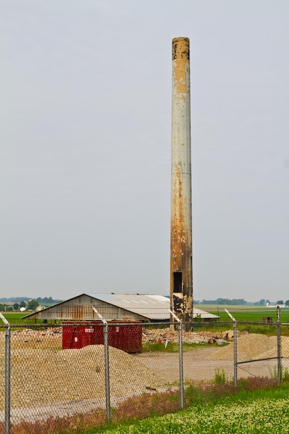 Foto la chimenea rústica domina el sitio industrial abandonado en la zona rural de evansville