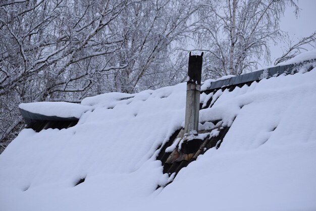 Chimenea sucia en el techo de una casa en invierno. estufa de calefacción durante la temporada de frío