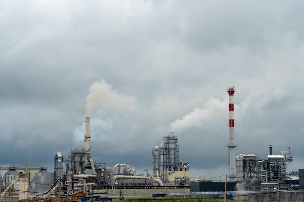 Chimeneas de fábrica contra el cielo gris de otoño Fondo de paisaje utópico Humo tóxico blanco proviene de una tubería enorme Contaminación del medio ambiente y la naturaleza El colapso de la civilización