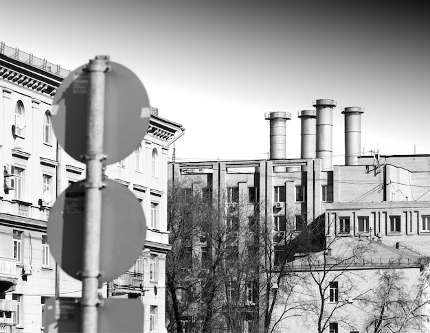 Foto chimeneas urbanas en blanco y negro con telón de fondo de señal de carretera