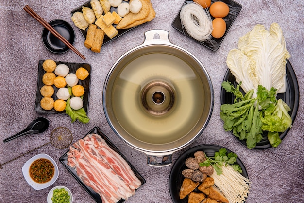 Chinese Hot Pot, auch bekannt als Suppenessen oder Steamboat, ist eine aus China stammende Kochmethode, die mit einem köchelnden Topf Suppenbrühe am Esstisch zubereitet wird