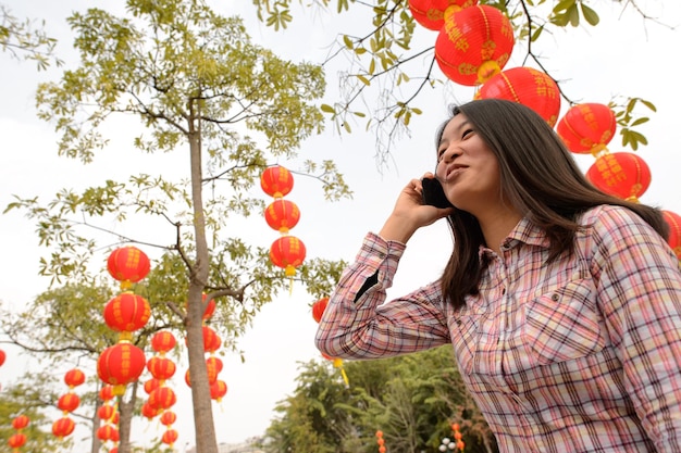 Chinesin, die während des chinesischen Neujahrs am Handy spricht