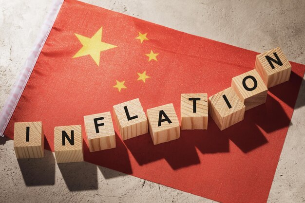 Chinesische Flagge und Holzwürfel mit Text, Konzept zum Thema Inflation in China