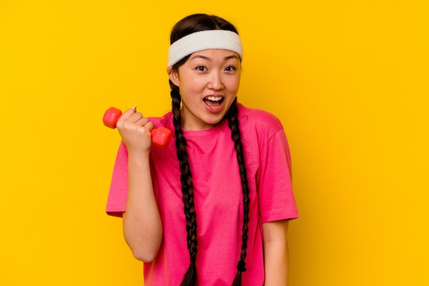 Chinesische Frau des jungen Sports lokalisiert auf gelbem Hintergrund