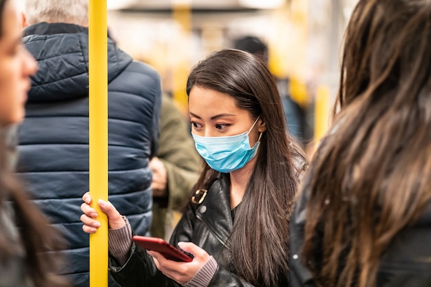 Chinesische Frau, die Gesichtsmaske im Zug trägt