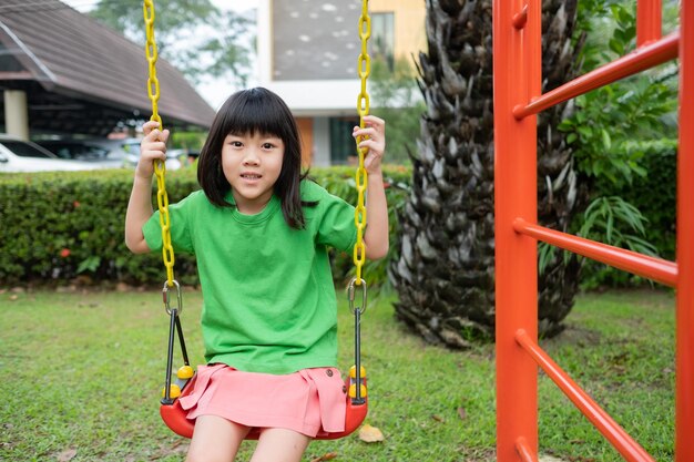 Chinesische Kinder, die Schaukel spielen, haben Spaß mit PlaygroundxA