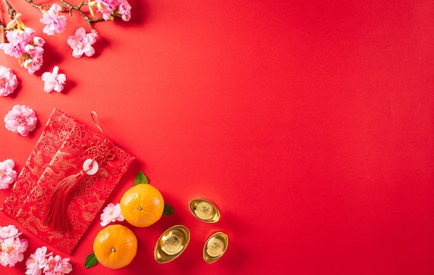 Chinesische Neujahrsdekorationen aus rotem Paket, Orangen- und Goldbarren oder goldener Klumpen auf rotem Hintergrund Chinesische Schriftzeichen FU in dem Artikel beziehen sich auf Glück, Glück, Reichtum, Geldfluss