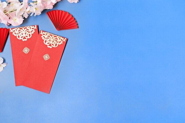 Chinesische Neujahrsfestdekorationen pow oder rote Umschläge mit Pflaumenblüte und roten Papierfächern