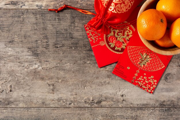 Chinesische Neujahrsfestdekorationen und Orangen auf hölzernem Hintergrund