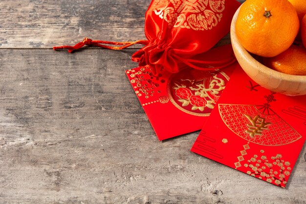 Chinesische Neujahrsfestdekorationen und Orangen auf hölzernem Hintergrund