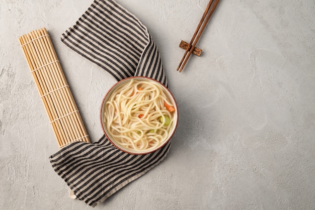 Chinesische Nudel oder Udon mit Gemüse und Essstäbchen auf lokalisiertem Weiß