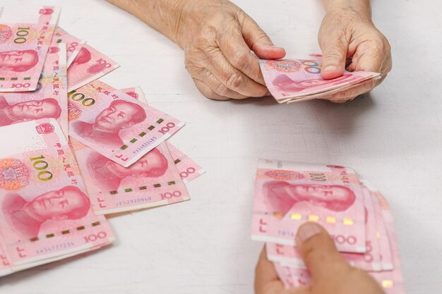 Chinesische Seniorin, die Geld für die Zahlung zählt