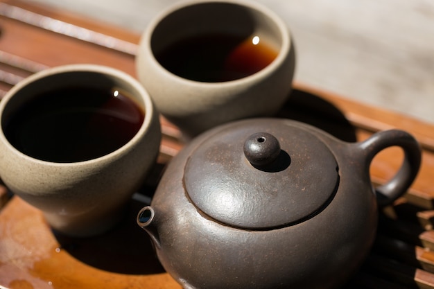 Chinesische Teezeremonie. Keramische Teekanne aus Ton und Schalen auf Holzhintergrund.