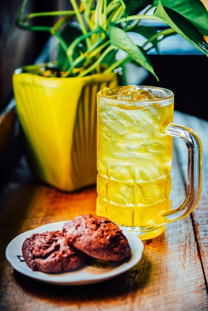 Foto chinesischer chrysanthemum-tee in großem glas und brownie-kekse auf einem holztisch gesundheitlicher kräutertee