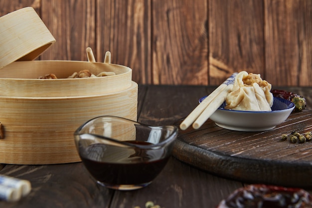 Foto chinesischer fleischknödel gedämpftes gericht in bambus-dampferbox mit essstäbchen und dimsum.