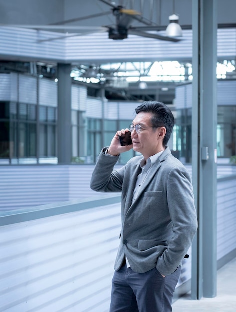 Chinesischer Geschäftsmann, der auf seinem Handy spricht