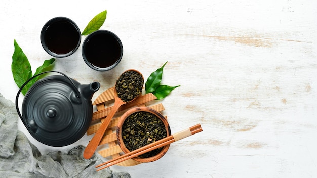 Chinesischer grüner Tee in einer Tasse mit Wasserkocher Auf weißem Holzhintergrund Draufsicht freier Speicherplatz für Ihren Text