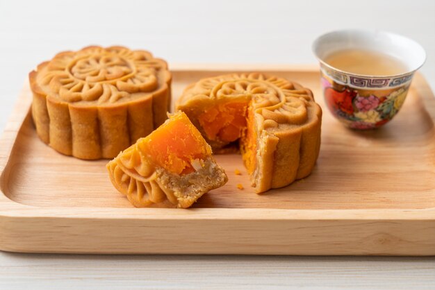 Chinesischer Mondkuchen Durian und Eigelb-Geschmack mit Tee auf Holzplatte