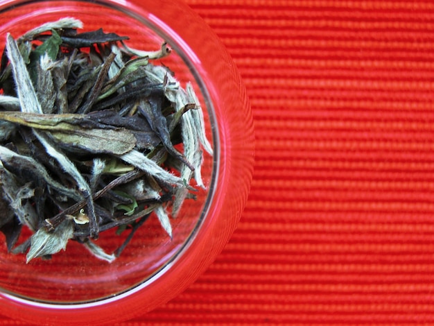 Chinesischer weißer Tee gegen roten Hintergrund