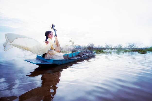 Chinesisches Mädchen spielt das traditionelle chinesische Musikinstrument auf den Booten