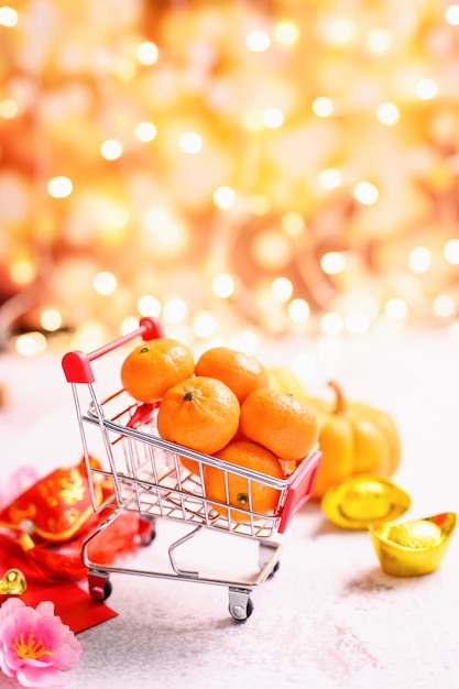 Chinesisches Neujahr, Einkaufswagen mit orangefarbenen und chinesischen Goldbarren, traditioneller asiatischer Stil (Fremdtext bedeutet Segen und Glück)