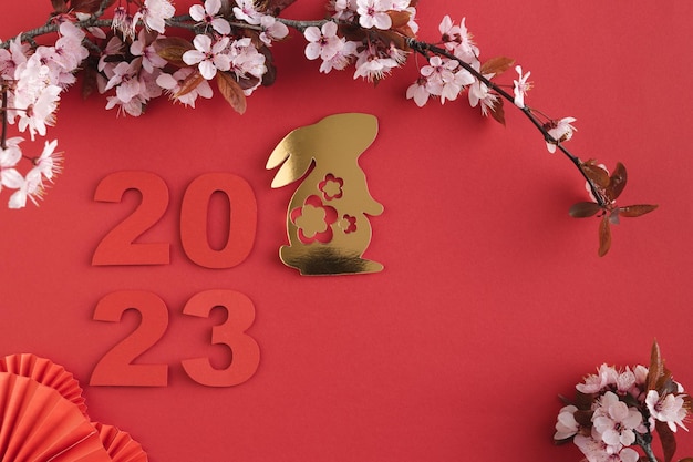 Chinesisches Neujahrsjahr des Kaninchens Jahr 2023 mit goldenen Kaninchen- und Pflaumenblütenfächern Platz kopieren