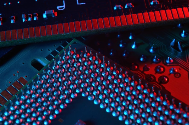 Foto chip do processador da cpu do computador no fundo da placa-mãe da placa de circuito closeup com iluminação redblue