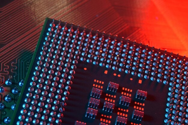 Chip de procesador de cpu de computadora en el fondo de la placa base de la placa de circuito Primer plano con iluminación roja y azul