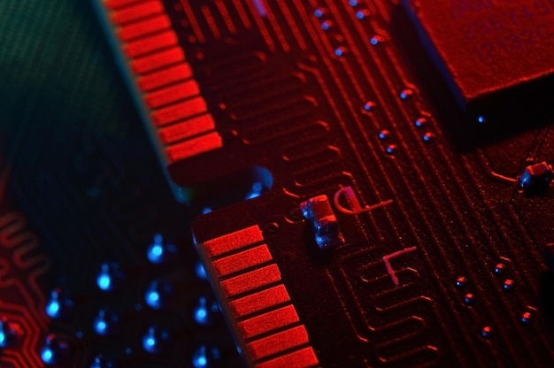 Chip de procesador de cpu de computadora en el fondo de la placa base de la placa de circuito Primer plano con iluminación roja y azul
