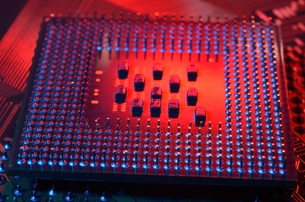 Foto chip de procesador de cpu de computadora en el fondo de la placa base de la placa de circuito primer plano con iluminación roja y azul