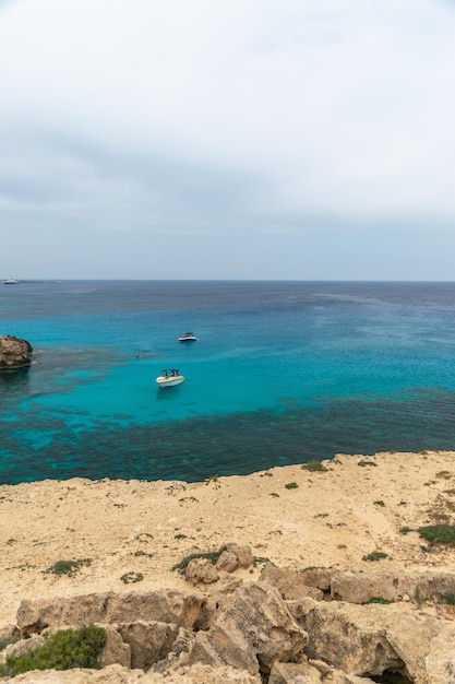 Foto chipre cabo cavo greco. os turistas navegaram em um barco a motor na lagoa azul para nadar