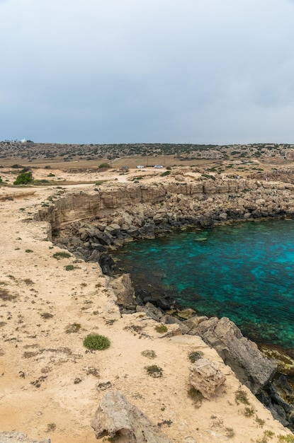 Foto chipre cabo cavo greco. los turistas llegaron en coche a la laguna azul para nadar