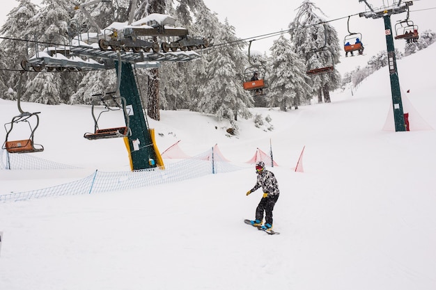 Chipre. Teleféricos e bondinhos subindo a montanha trazendo snowboarders às pistas de esqui.