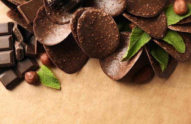 Chips de chocolate y hojas de menta sobre fondo de pergamino