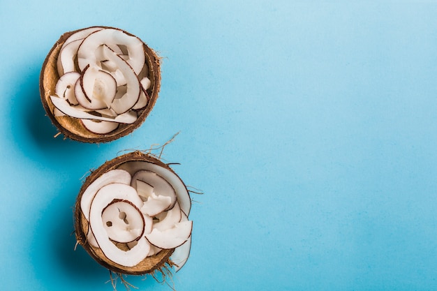 Chips de coco en un tazón de coco en un azul