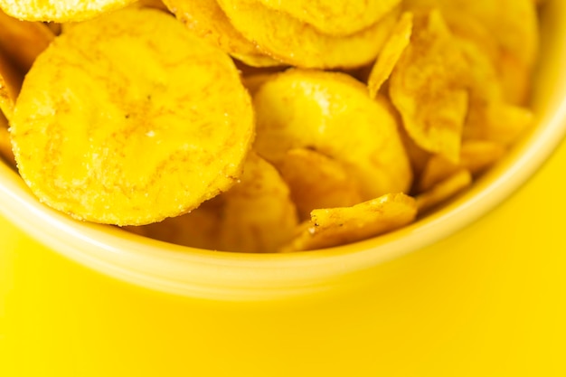 Chips de banana assada em tigela amarela um lanche saudável